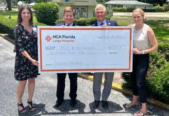 A check presentation from HCA Florida-Largo donation to the Greater Ridgecrest YMCA and Clearwater Y in Motion. Four people holding up the check. 