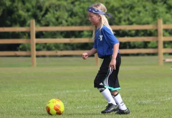 one child playing soccer outdoor field
