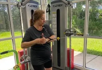 A participant in the Moffitt Cancer Survivorship works out, demonstrating a standing cable oblique twist.