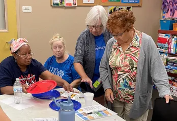 4 active older adult members (women) reading information