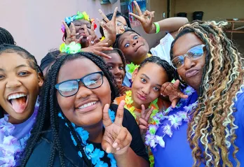 BTAG Participants pose for photo. They are wearing leis and making a peace sign.