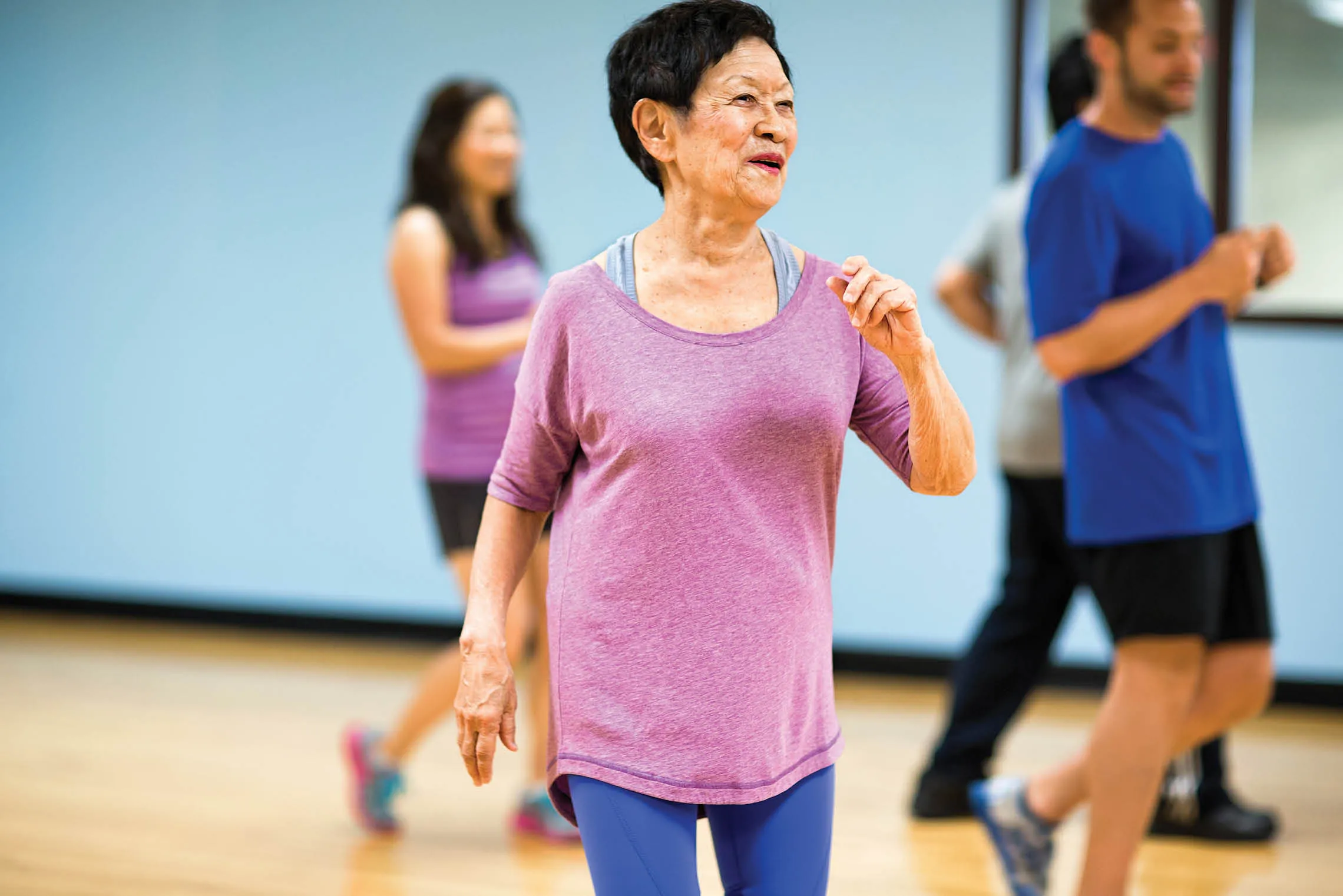 Older woman moving in exercise class in gym