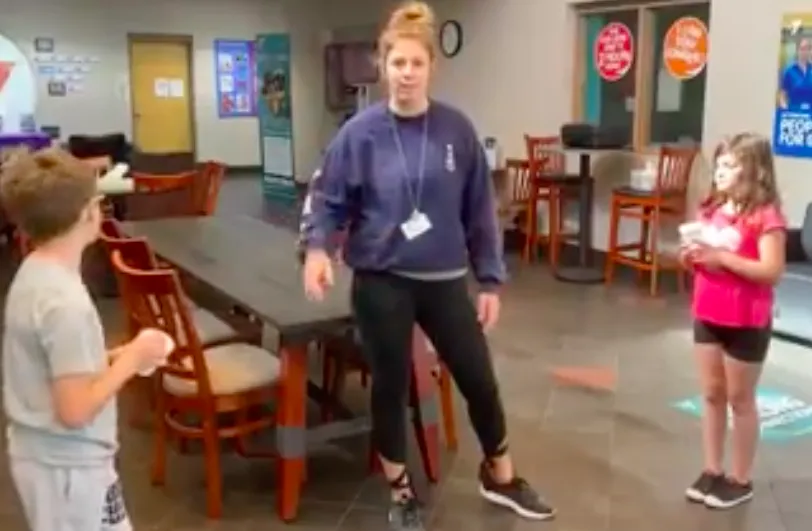 y staff and two kids standing for minute to win it game