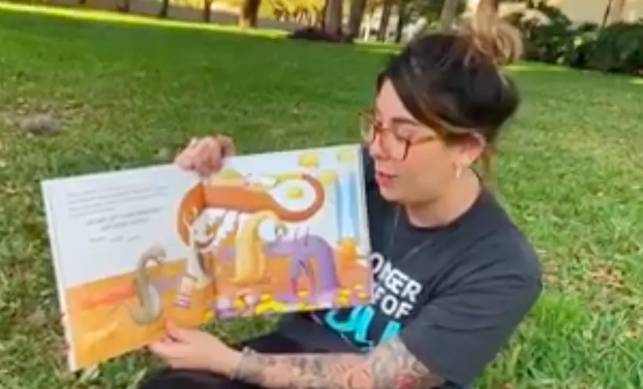 y staff sitting outside reading book