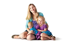 woman sitting on ground with kid and baby