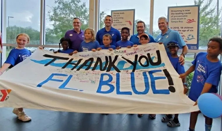 Young swimmers along with Y CEOs (L to R: YMCA of Greater St. Petersburg President/CEO David Jezek, Tampa Metropolitan Area YMCA President/CEO Matt Mitchell, Florida Blue’s Market President, West Florida Region David Pizzo, YMCA of the Suncoast President/CEO G. Scott Goyer) thank the Florida Blue Foundation for their generous donation to the Y’s Safety Around Water program. 