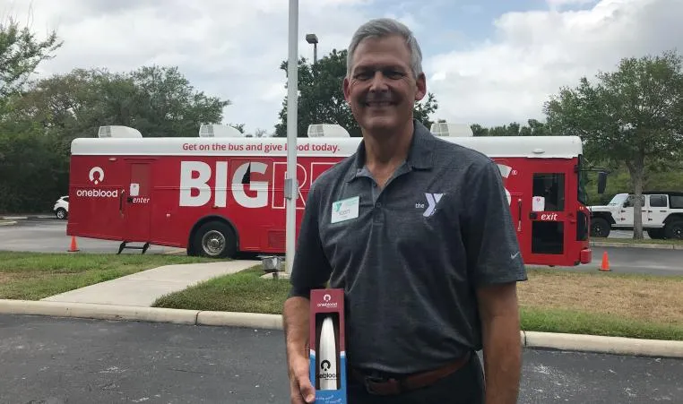 CEO, Scott Goyer smiling outside of the Big Red Bus with OneBlood