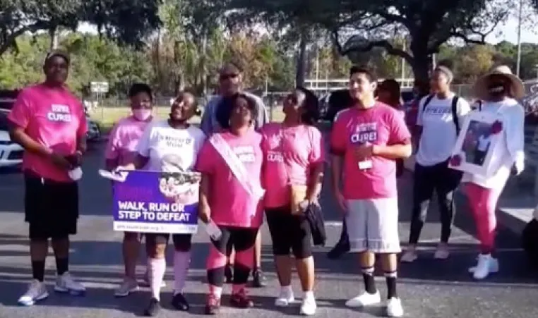 A group of adults wearing pink gathered for a photo before the breast cancer awareness walk at the Greater Ridgecrest YMCA.