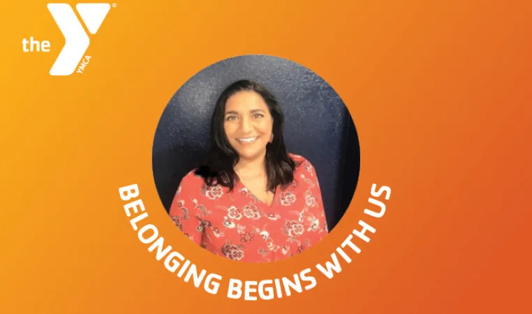 orange gradient background with white Y logo top left. Image of woman centered in circle. Curved white text beneath image reads Belonging Begins With Us