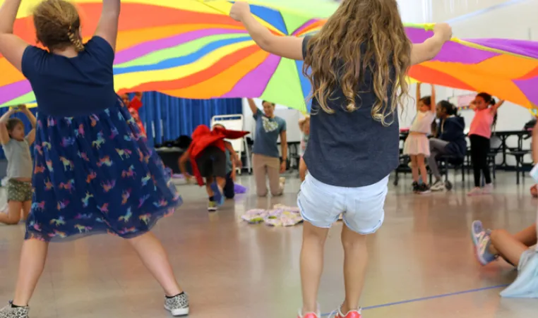 Kids lifting giant colorful round parachute during an indoor activity from BayCare Kids Power program.jpg