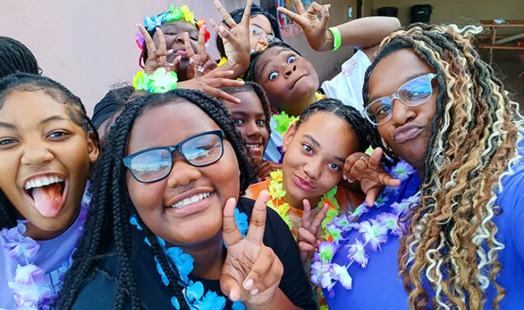 BTAG Participants pose for photo. They are wearing leis and making a peace sign.