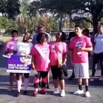 A group of adults wearing pink gathered for a photo before the breast cancer awareness walk at the Greater Ridgecrest YMCA.