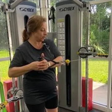 A participant in the Moffitt Cancer Survivorship works out, demonstrating a standing cable oblique twist.