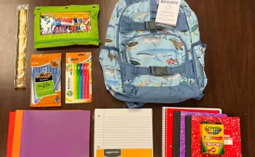 backpack and school supplies laid flat on the table
