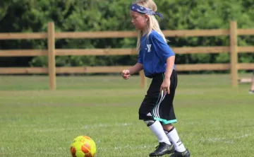 one child playing soccer outdoor field