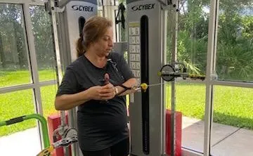 A participant in the Moffitt Cancer Survivorship works out, demonstrating a standing cable oblique twist.