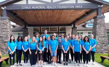 23 Teens in blue YOuth Leasership t-shirts in front of Citrus Memorial Health Foundation YMCA