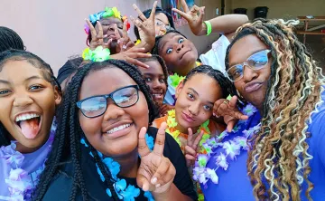 BTAG Participants pose for photo. They are wearing leis and making a peace sign.
